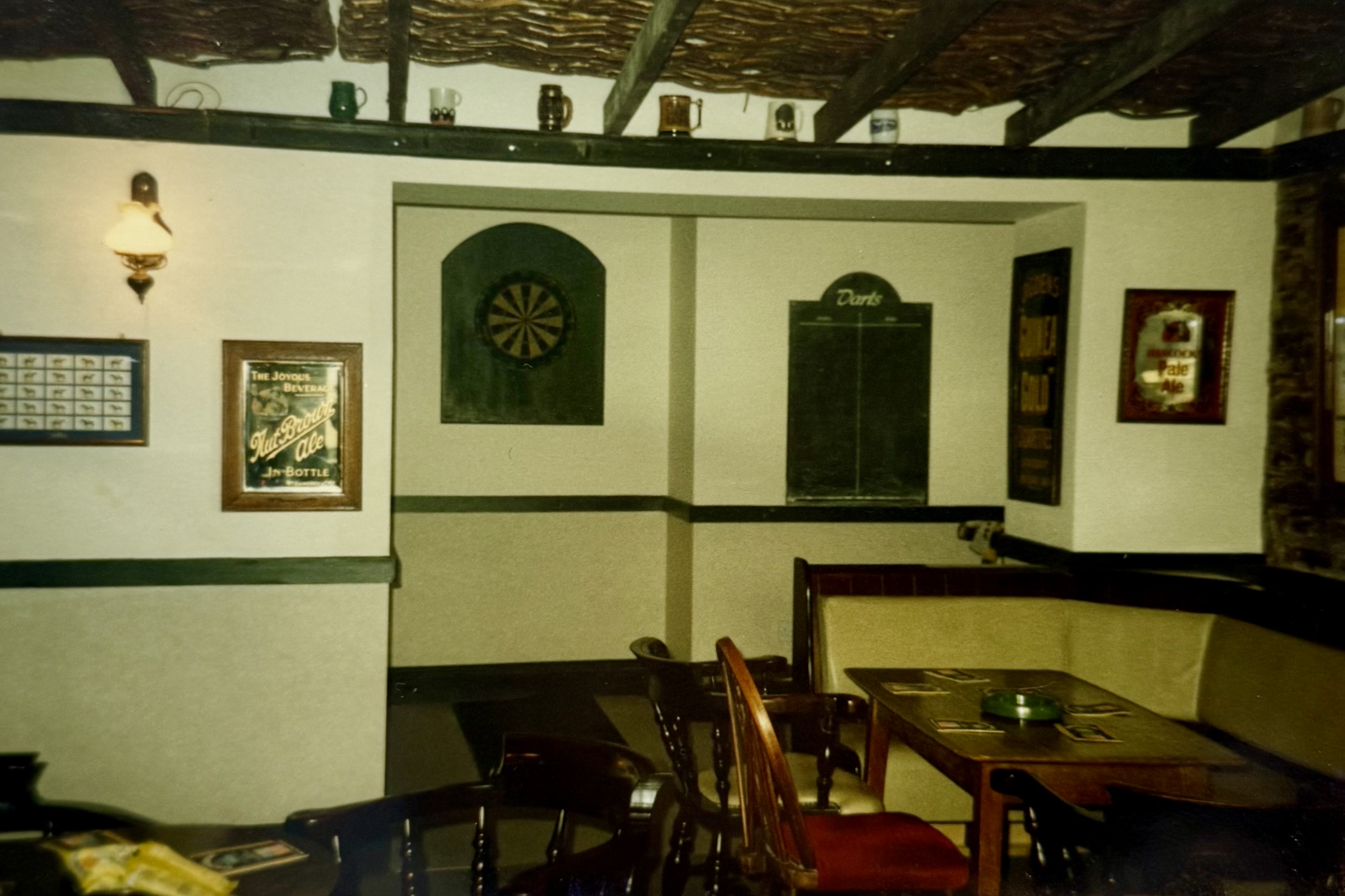 Taken from the Bar area, showing what is now the Snug before renovations. The area contains a dartsboard and a blackboard for darts scores.