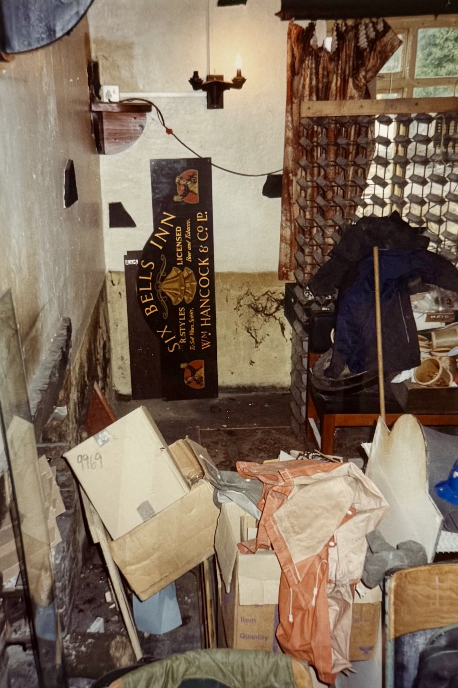 The sign which now sits above the fireplace in the Bar. The sign is located where the Kitchen door is now, and the photo shows the window which was removed during the renovation.