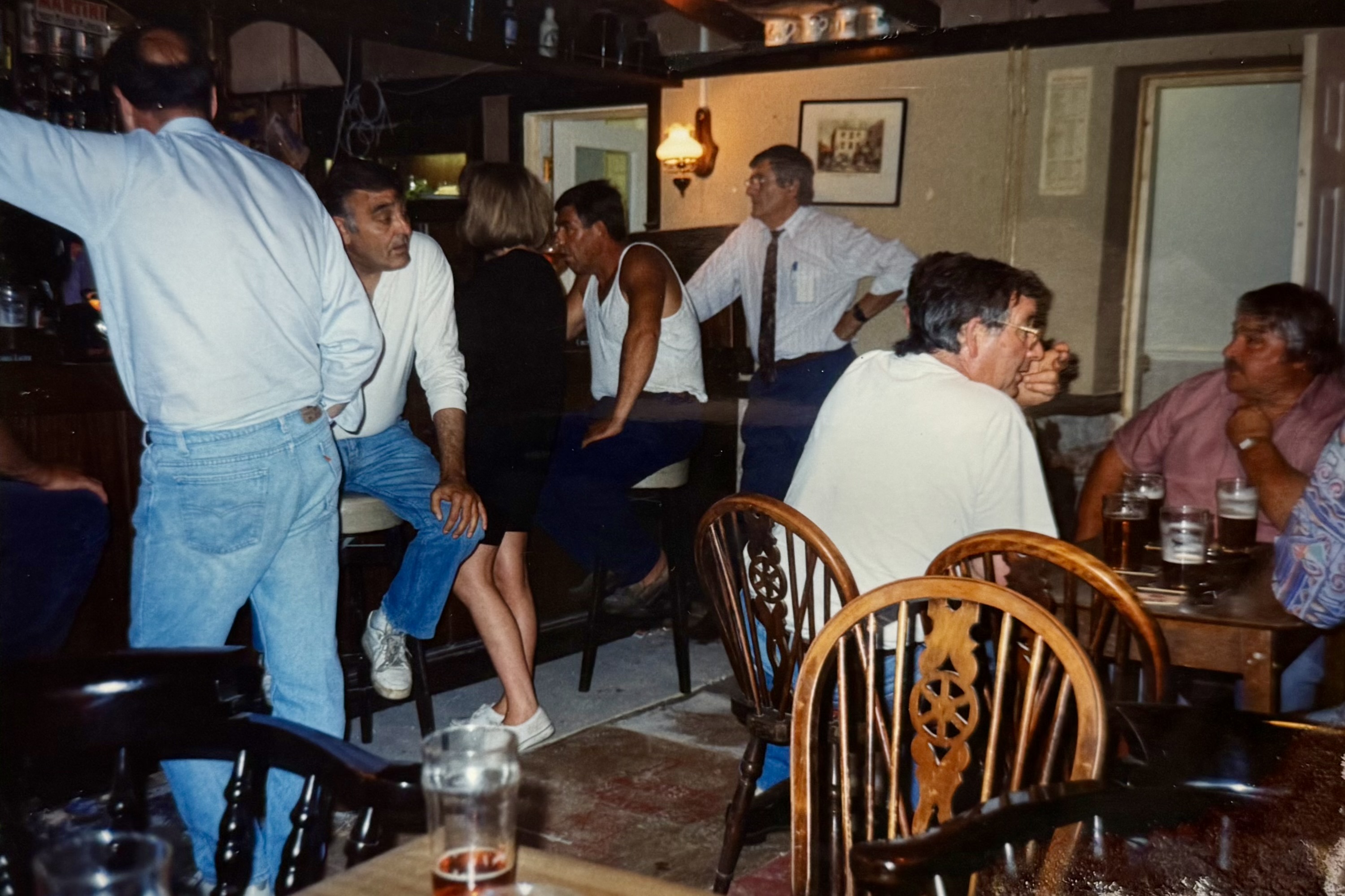 People stood around the Bar area, taken from near the window.