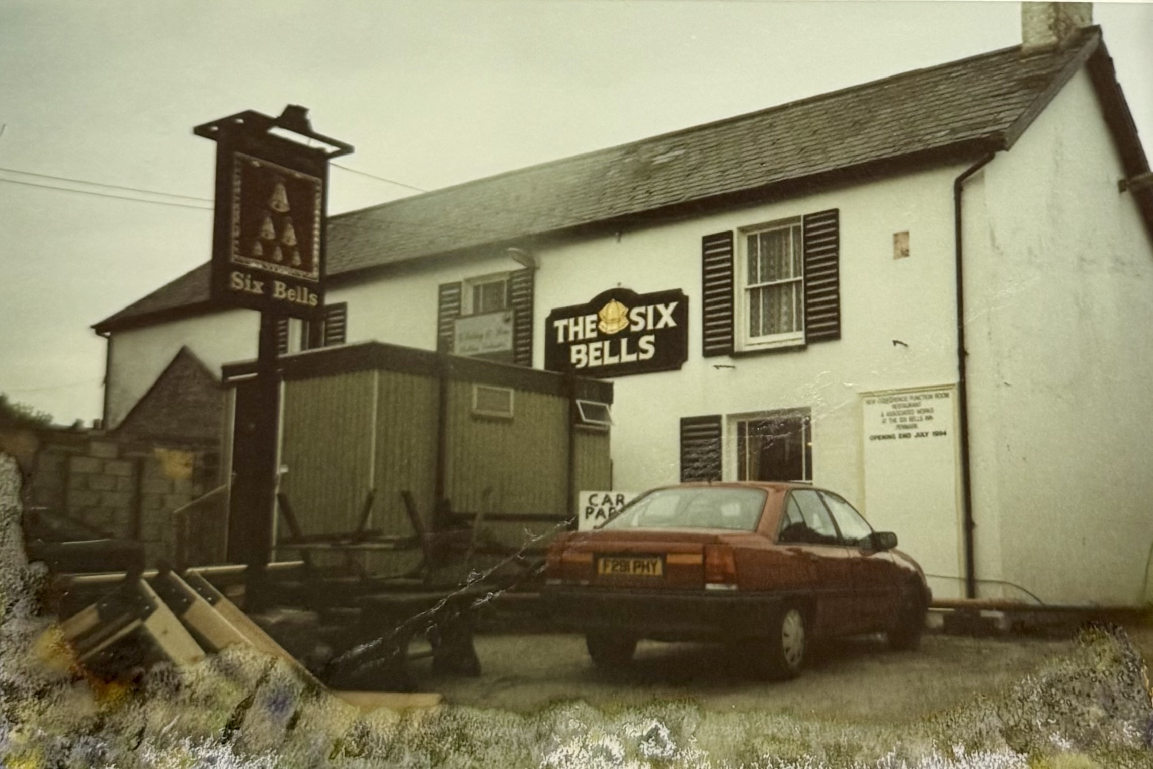The front of the pub, showing a car parked and all the picnic tables and benches cordoning off the area which would soon become the Restaurant. On the wall you can read: NEW CONFERENCE/FUNCTION ROOM, RESTAURANT & ASSOCIATED WORKS AT THE SIX BELLS INN PENMARK OPENING END JULY 1994.