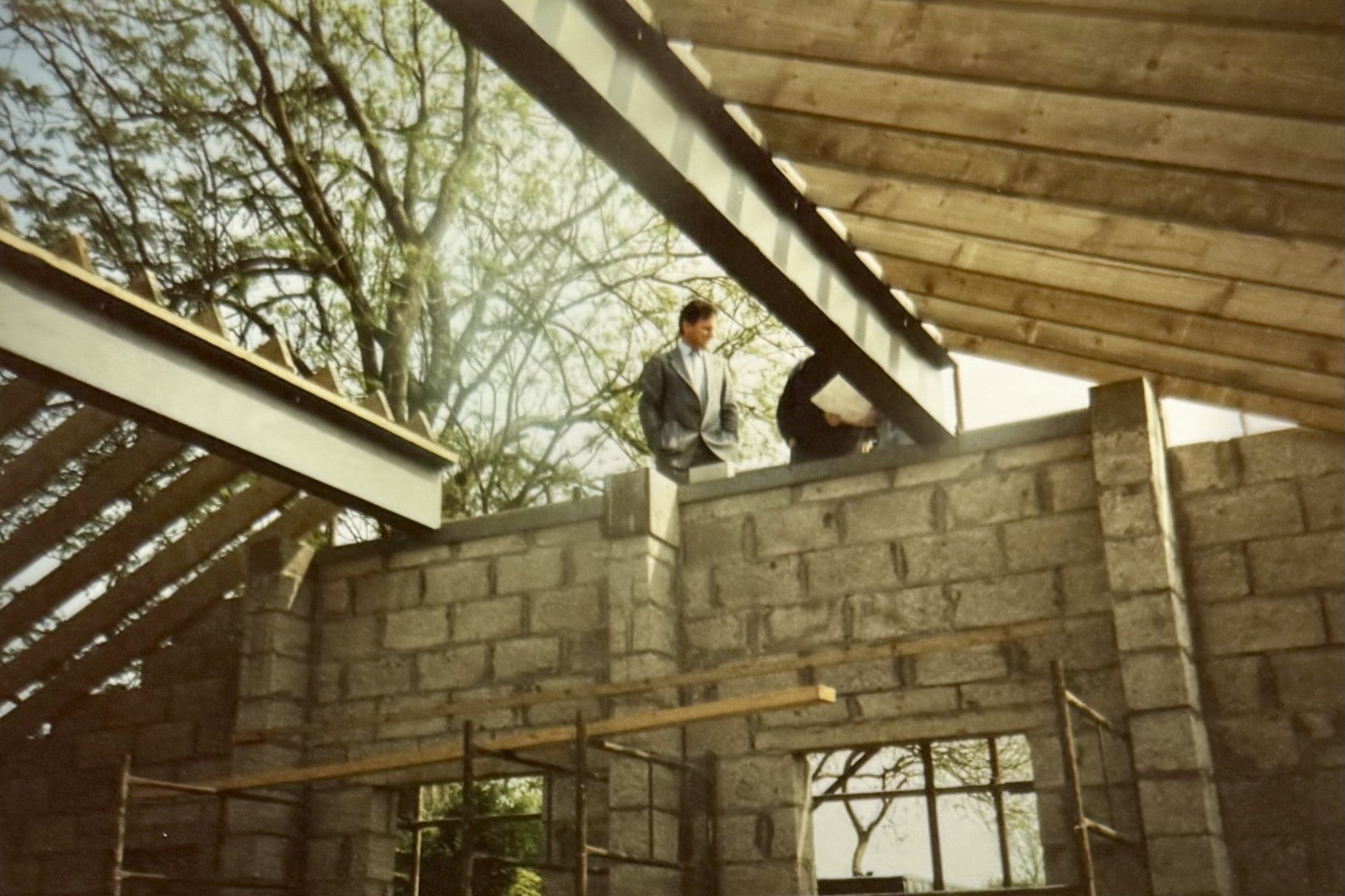 Some men stood on the scaffolding which was outside the Function Room top window - the roof has not yet been put on in the middle, but the main beams and the side structures have been placed.