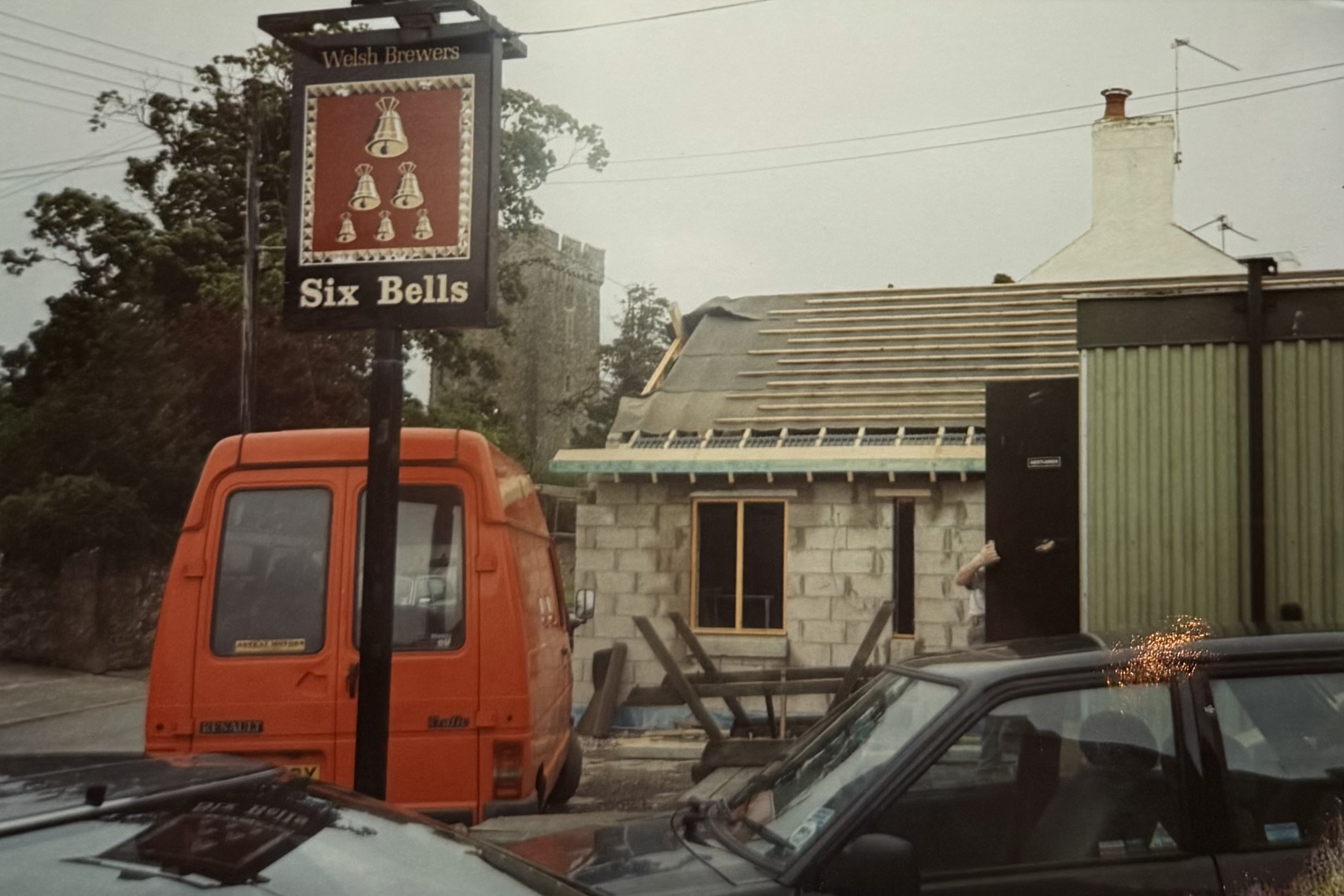 The hanging sign shown from a different angle, with St Mary's Church visible right behind.