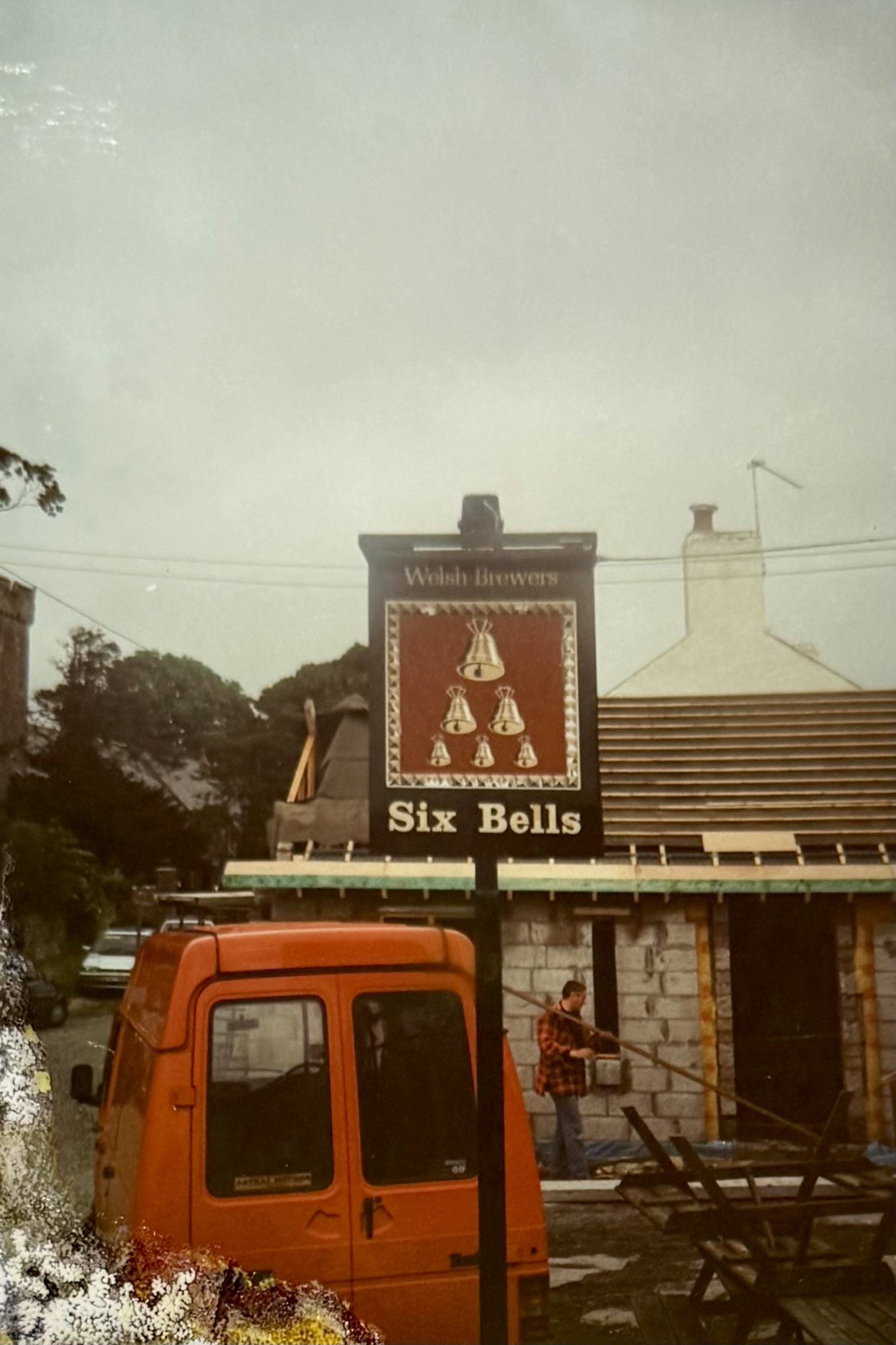 The previous hanging sign outside the front of the pub, with the unfinished Restaurant in the background.