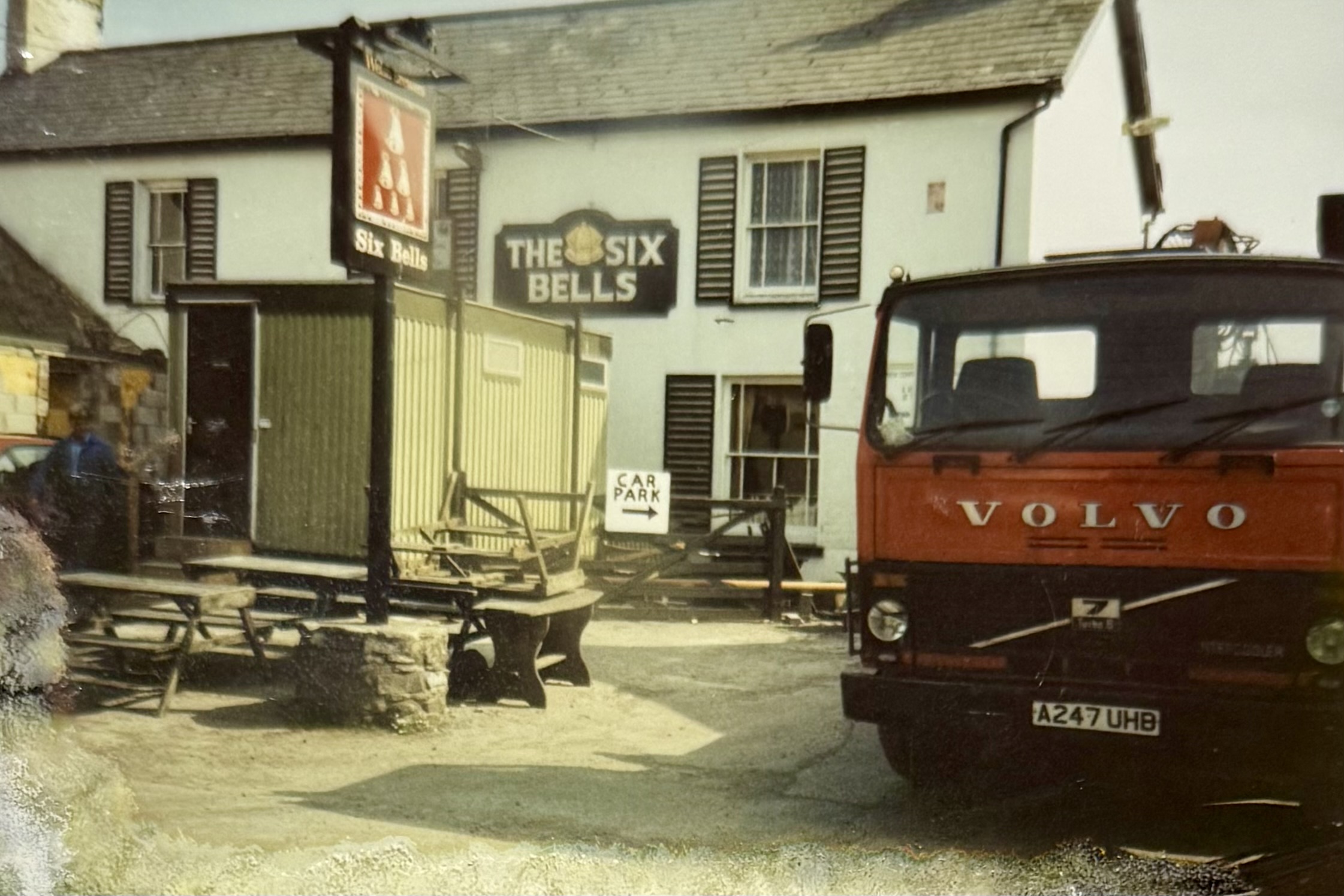 A Volvo lorry parked to the side of the pub, with renovations underway in the background.